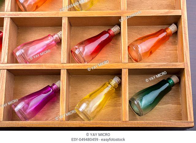 Colorful small bottles in a wooden box in the view