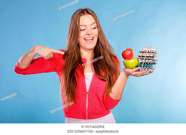 Woman girl holding vitamin tablets pills and fruits. Choice between natural and synthetic vitamins. Health care. Healthy lifestyle nutrition concept