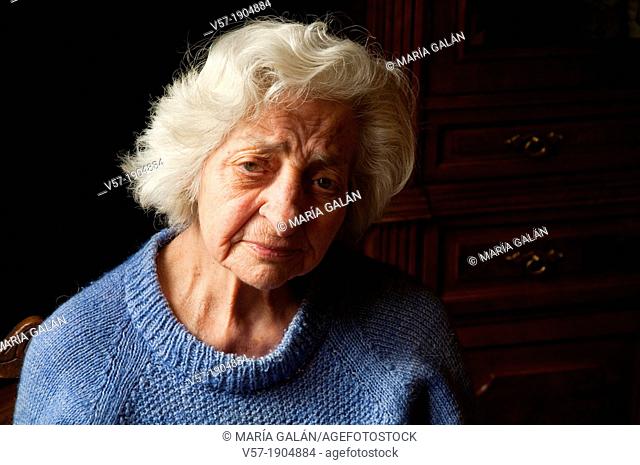Portrait of old woman at home, looking at the camera. Close view