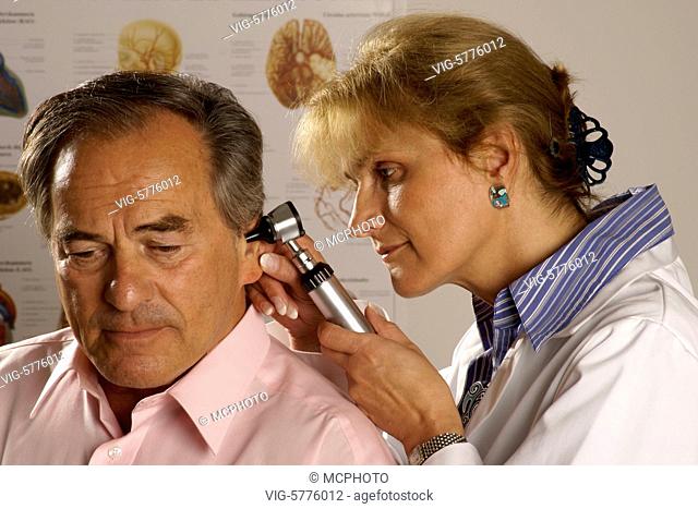 Eine Aerztin untersucht die Ohren von einem aelteren Mann, MR, 2007| A lady doctor examined the ears from a old man - Hamburg, Hamburg, Germany, 27/07/2007