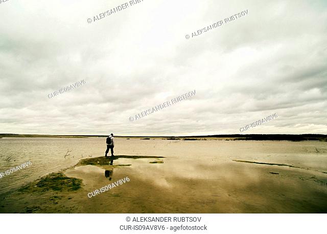 Young man hiking beside lake