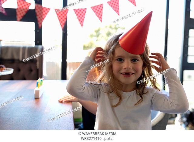 Girl in party hat at home