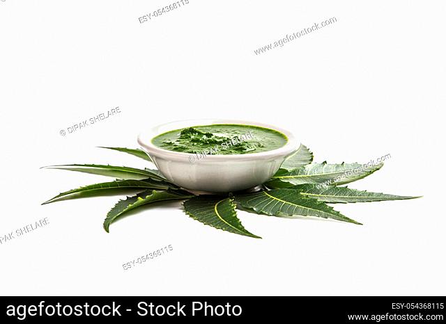 Medicinal Neem leaves with paste in bowl on white background