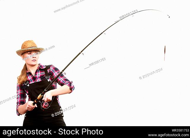 Spinning equipment, angling, cheerful fisherwoman concept. Focused woman in sun hat holding fishing rod hunting and fighting with fish on hook