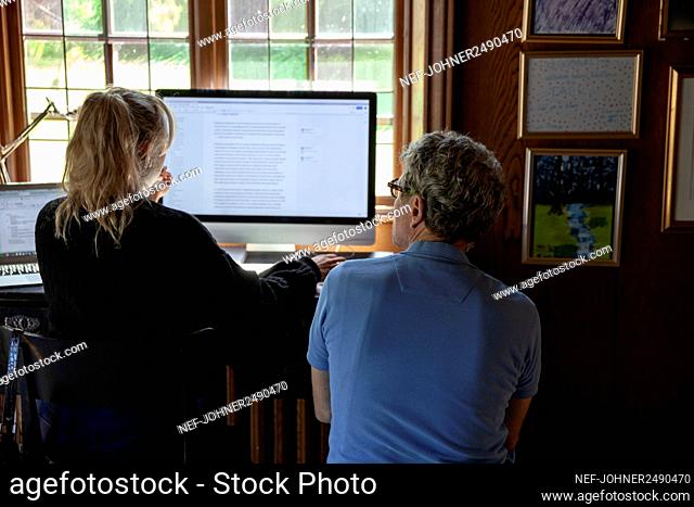Father with adult daughter looking at computer screen