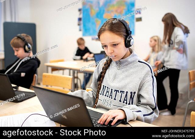 Girl in classroom using laptop