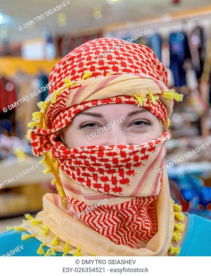 A girl of Slavic appearance wearing Arabic headdress. The girl looks at the camera close-up. Portrait