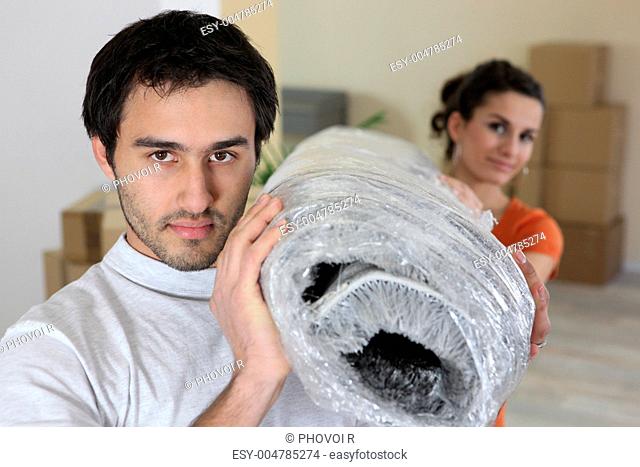 Couple carrying a rug