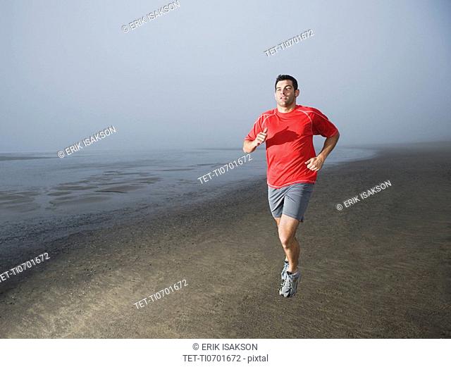 Man jogging on foggy beach