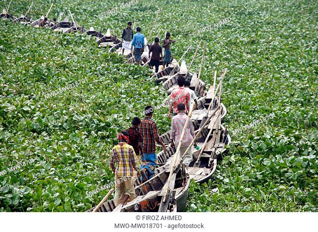 People are crossing Buriganga river by a makeshift bridge made of boats in Kamrangir Char, in Lalbagh area of Old Dhaka Usually boats are used to ferry people...