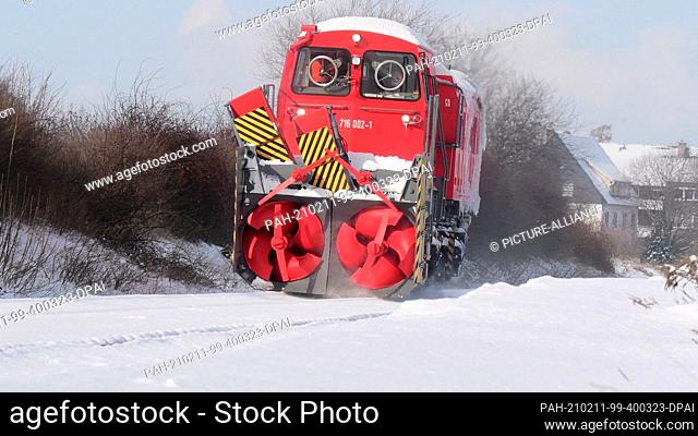 11 February 2021, Lower Saxony, Brunswick: A Deutsche Bahn snow blower frees the Braunschweig - Wolfenbüttel train line from the snow