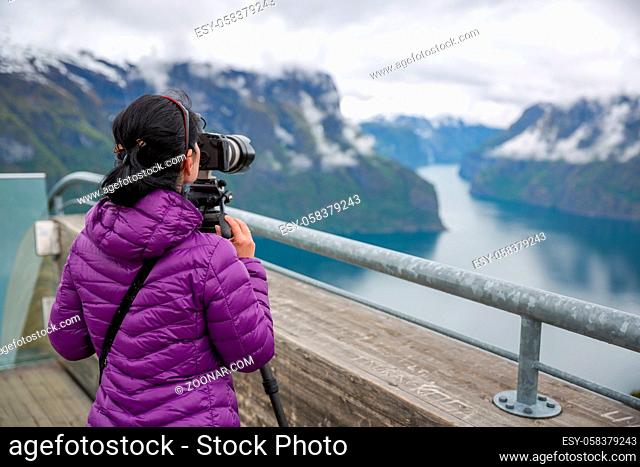 Nature photographer tourist with camera shoots. Stegastein Lookout. Beautiful Nature Norway