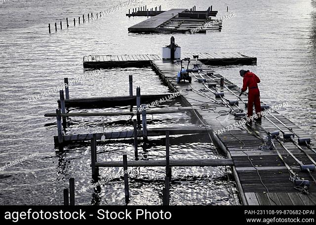 08 November 2023, Hamburg: A high-pressure cleaner is used to clean the jetty and moorings of Bodo's Bootssteg at the Rabenstraße jetty on the Outer Alster and...