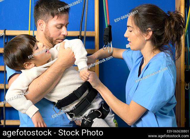 Physiotherapists Preparing a children with disability for rehabilitation treatment in hospital. High quality photography