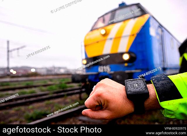 A worker demonstrates a wrist watch showing a notification at the presentation of two new safety systems of railway infrastructure firm Infrabel