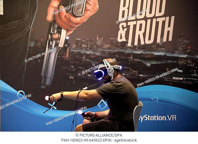 21 August 2018, Germany, Cologne: A visitor of Gamescom plays with the Sony Playstation. For the tenth time the Computer Spielemesse takes place in Cologne