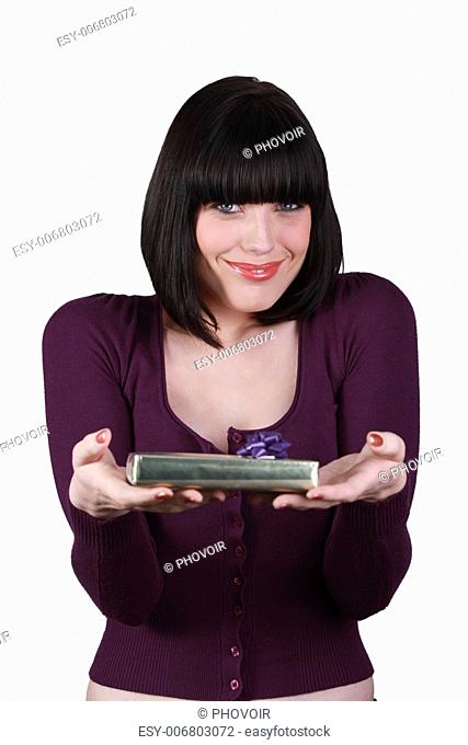 Woman with playful smile showing gift