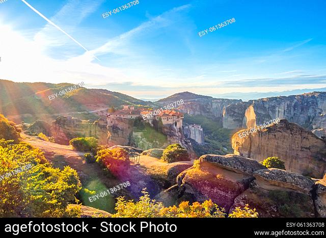 Greece. Summer dawn over a Greek rock monastery in Meteora (near Kalambaka). Colored sun rays