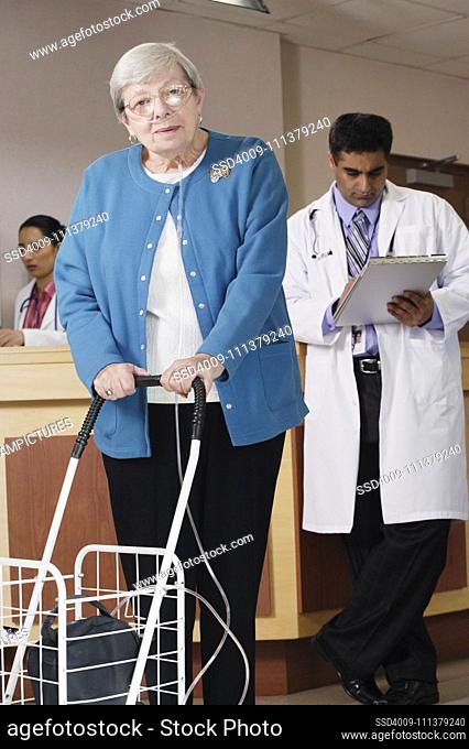 Elderly woman using a walker and a respirator