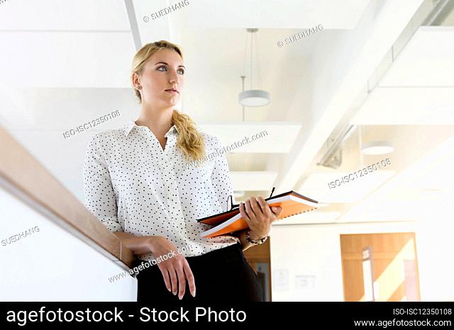 Germany, Bavaria, Munich, Young businesswoman standing in office