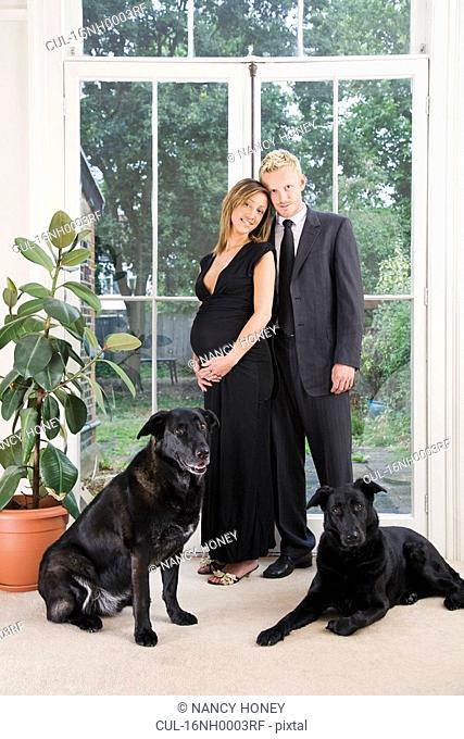 Caucasian pregnant couple and dogs