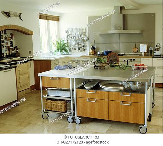 Large moveable island unit on castors in modern white kitchen with limestone floor tiles