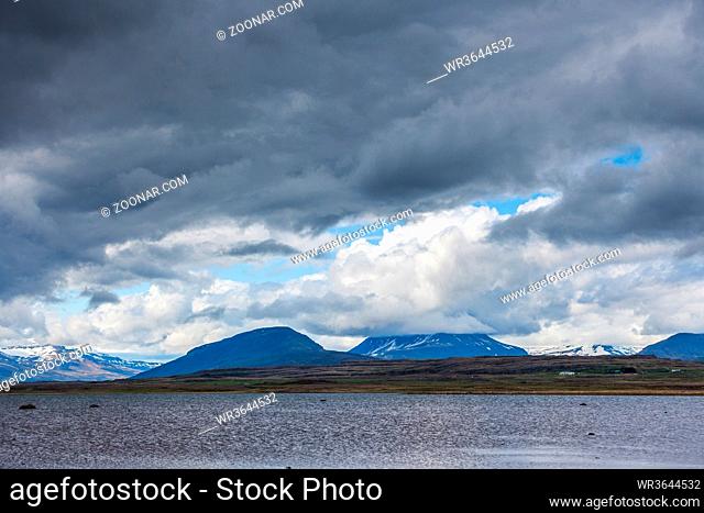 calm lake with mountains in the background and a cloudy sky on Iceland