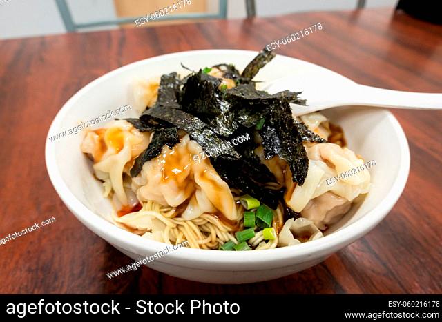 spicy wontons with noodles and sea sedge in a bowl