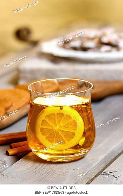 Glass of hot tea on rustic wooden table. Cozy home