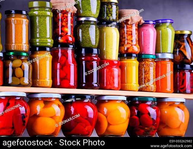 Jars with variety of pickled vegetables and fruits. Preserved food