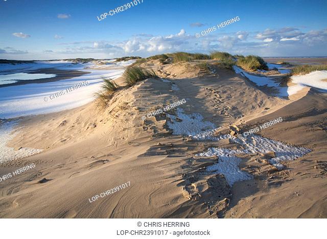 England, Norfolk, Holkham Bay. Winter snow on the beach and sand dunes at Holkham Bay on the North Norfolk Coast