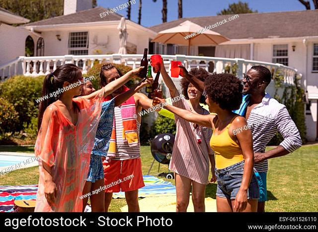 Diverse group of friends making toast at a pool party