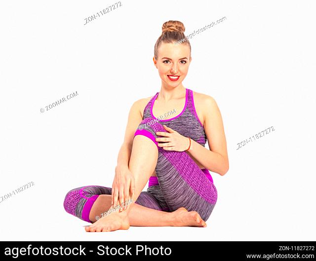 Attractive girl sitting on the floor. Yoga allows them to develop flexibility and strengthen muscles. Isolated image