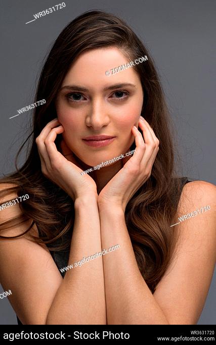 beautiful young brunette woman in a gray dress posing and expresses different emotions. close-up portret
