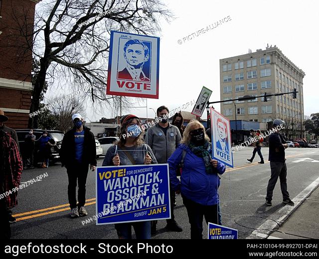 02 January 2021, US, Athens: Chandra (l) and Sheila hold up posters at a campaign appearance by Democratic candidate Jon Ossoff