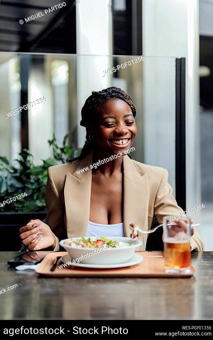 Cheerful woman having food at cafe