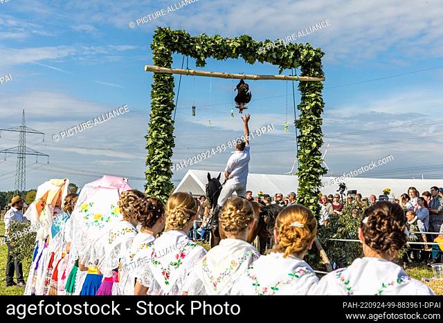 24 September 2022, Brandenburg, Neu Zauche: Young women in Sorbian/Wendish traditional costumes stand by the competition track at the Super Kokot