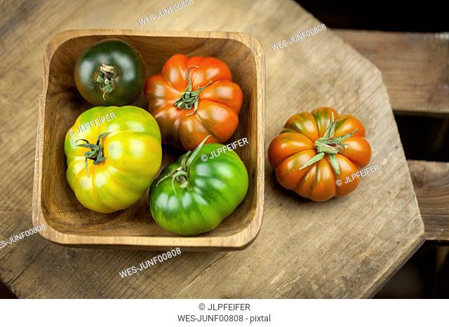 Wooden bowl of various Oxheart Tomatoes