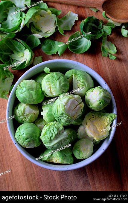 White bowl with delicious Brussels sprouts on wooden