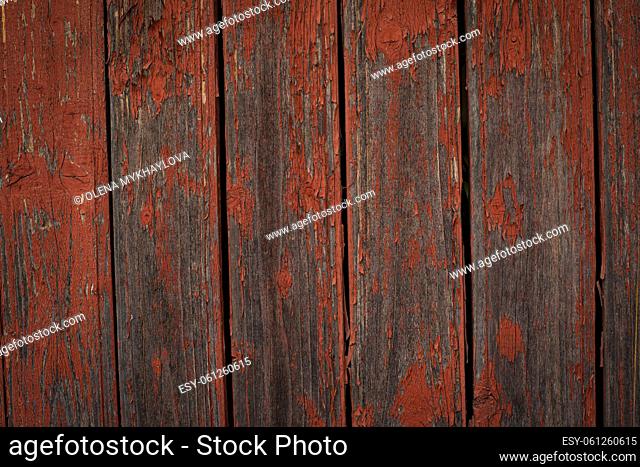 Old natural weathered wooden planks with cracked red paint background