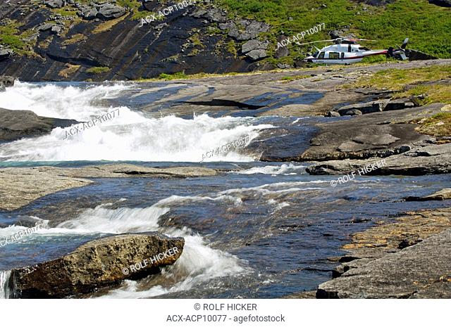 Waterfall with a helicopter in the background in the Mealy Mountains in Southern Labrador, Newfoundland & Labrador, Canada