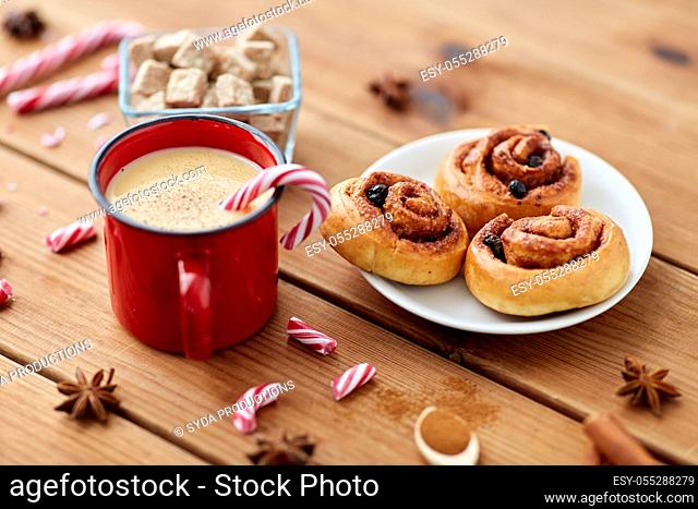 eggnog with candy cane in cup and cinnamon buns