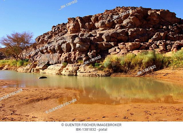 Water rest in a riverbed near the prehistoric archaeological sites in Wadi Mathendous, Mesak Settafet Plateau, Libya, Africa