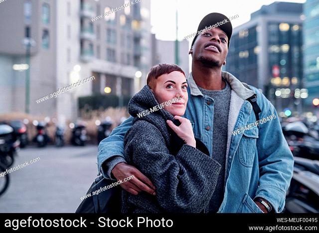 Young couple in the city at dusk, Milan, Italy