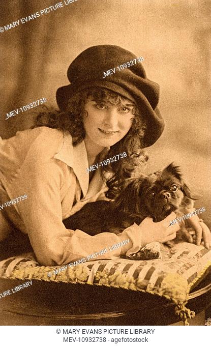 Studio portrait, young woman with a Pekingese dog