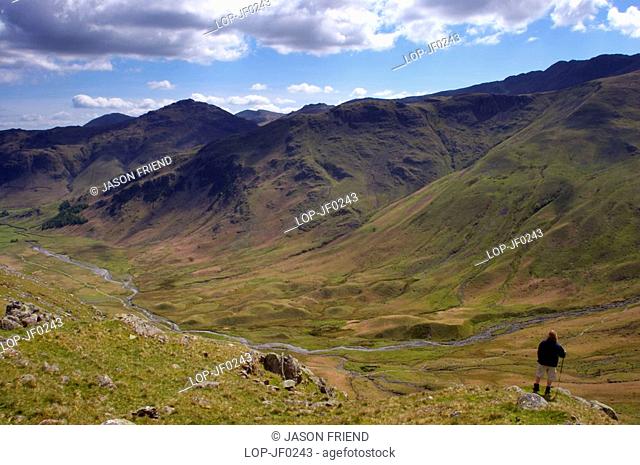 England, Cumbria, Mickleden Valley, A hiker admires the impressive wild scenery of the Mickleden Valley