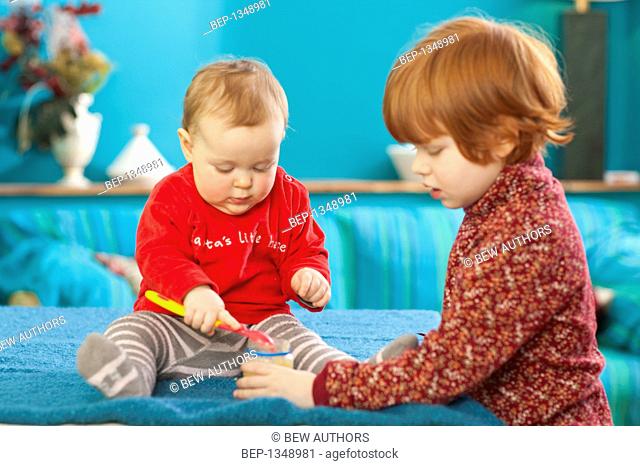 Red-haired girl feeding her younger sister