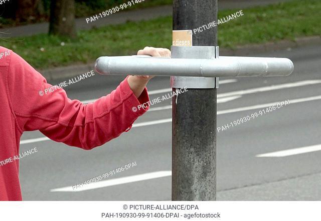 24 September 2019, Schleswig-Holstein, Flensburg: A cyclist is heading for one of the new handles on the traffic light mast