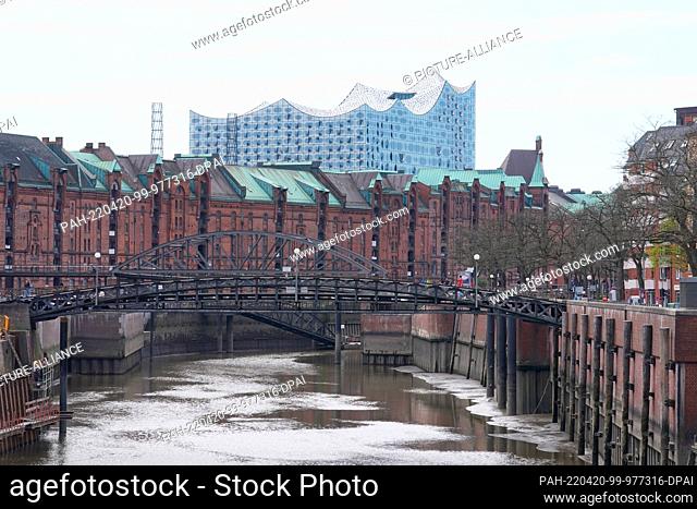 20 April 2022, Hamburg: View of the Elbe Philharmonic Hall in Hafencity. The warehouses of the historic Speicherstadt can be seen in the foreground