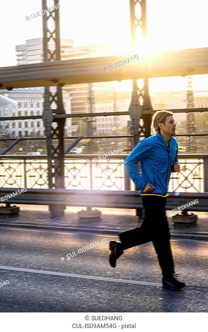 Man jogging on bridge, Munich, Bavaria, Germany
